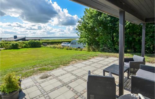 a patio with chairs and a view of a yard at Cozy Home In Øster Assels With Wifi in Øster Assels