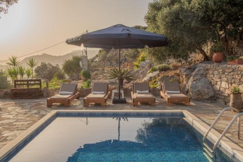 a swimming pool with chairs and an umbrella and an umbrella at Cretan Nature Villa Alexandra in Zarós