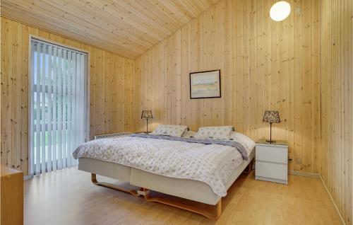 1 dormitorio con 1 cama en una pared de madera en 3 Bedroom Lovely Home In Vggerlse, en Bøtø By