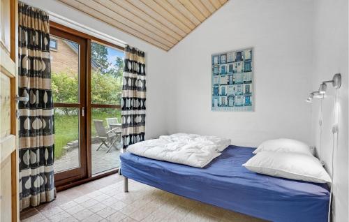 エーベルトフトにあるPet Friendly Home In Ebeltoft With Kitchenのベッドルーム1室(青いシーツと窓付)