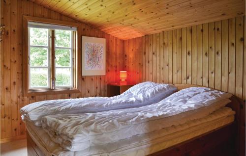 - une chambre avec un lit dans un mur en bois dans l'établissement Nice Home In Kirke Hyllinge With Wifi, à Kirke-Hyllinge