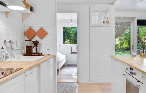 a kitchen with white cabinets and a sink at Amazing Home In Aakirkeby With House Sea View in Vester Sømarken