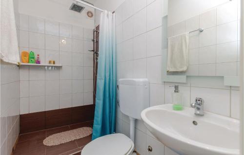 y baño con aseo, lavabo y ducha. en Stunning Apartment In Kostrena With Kitchen, en Kostrena