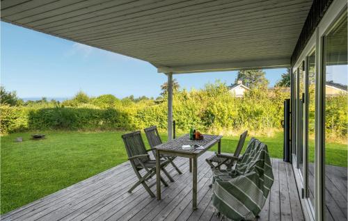 a patio with a table and chairs on a deck at 4 Bedroom Stunning Home In Fårevejle in Fårevejle