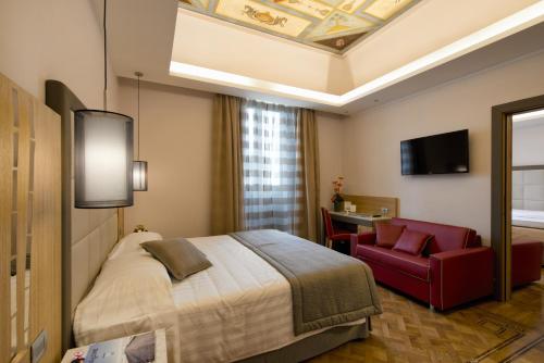 um quarto de hotel com uma cama e uma cadeira vermelha em Vibe Nazionale em Roma
