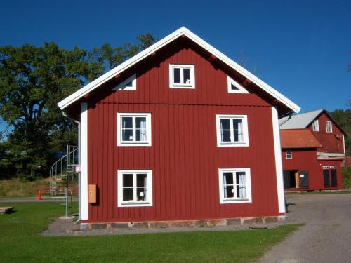 a red house with white windows in a field at Skeppsdockans Vandrarhem in Söderköping
