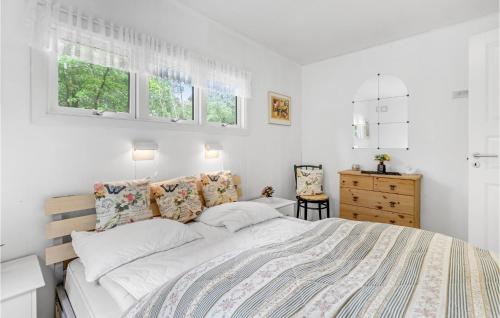 a white bedroom with a large bed and windows at Baluka in Bedegård