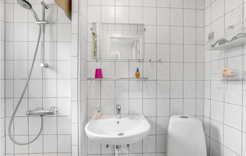 a white bathroom with a sink and a shower at Baluka in Bedegård