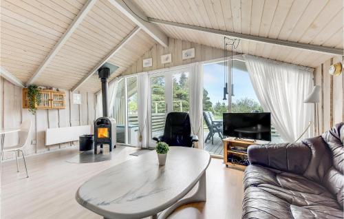 a living room with a table and a fireplace at Holiday Home Ringvejen Rømø I in Bolilmark