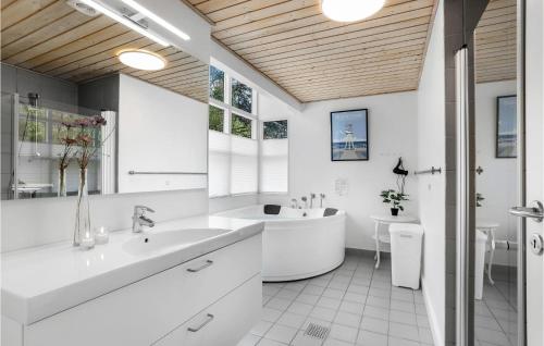 Tofte的住宿－Rubinsen Skovhuse，白色的浴室设有浴缸和水槽。