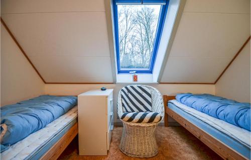 エーベルトフトにあるNice Apartment In Ebeltoft With Wifiのベッド2台と窓が備わる客室です。