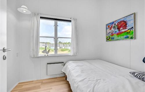 een witte slaapkamer met een bed en een raam bij Muslingen 721 in Ebeltoft