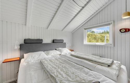 1 dormitorio con 1 cama blanca grande y ventana en Cozy Home In Vejers Strand With Outdoor Swimming Pool, en Vejers Strand
