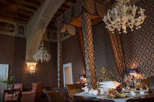 a dining room with a table and a chandelier at Castello di Guarene in Guarene