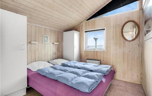 Bjerregårdにある2 Bedroom Awesome Home In Hvide Sandeの鏡付きの部屋の大型ベッド1台