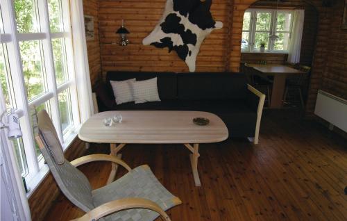 a room with a couch and a table and a cow on the wall at Holiday Home Ridderstien in Spidsegård