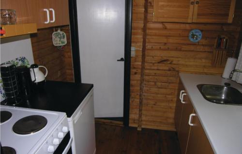 a small kitchen with a stove and a sink at Holiday Home Ridderstien in Spidsegård