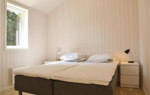 a bedroom with a bed with two pillows and a window at Amazing Home In Tikb With Kitchen in Tikøb