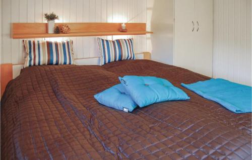 two blue pillows sitting on top of a bed at Lovely Home In Hvide Sande With Private Swimming Pool, Can Be Inside Or Outside in Havrvig