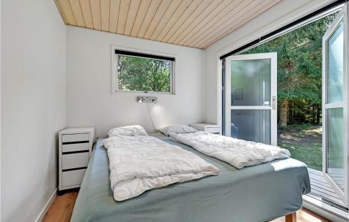 1 dormitorio con cama y ventana en Stunning Home In Ebeltoft With Kitchen en Øksenmølle