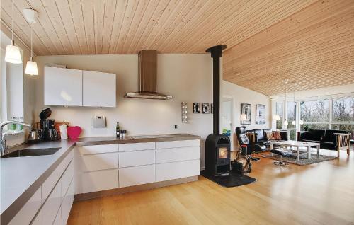 a kitchen with white cabinets and a living room at Awesome Home In Vinderup With Wifi in Vinderup