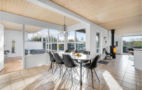 a kitchen and dining room with a white table and chairs at Four-Bedroom Holiday Home In Juelsminde in Sønderby