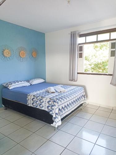 Un dormitorio con una cama con paredes azules y una ventana en Itapuã Corais Hostel e Pousada, en Salvador