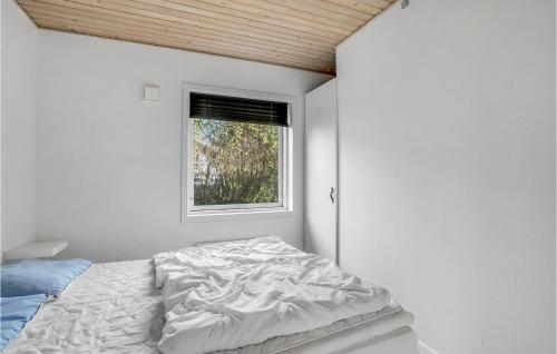 a white bedroom with a bed and a window at Four-Bedroom Holiday Home In Juelsminde in Sønderby