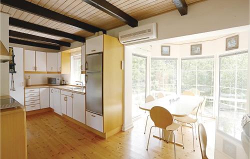 a kitchen with a table and chairs and a kitchen with a table and a table at Tefres in Snogebæk
