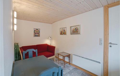 ein Wohnzimmer mit einem roten Sofa und einem Tisch in der Unterkunft Lrkereden, in Allinge