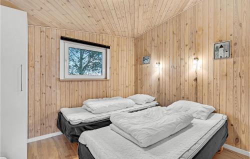 2 camas en una habitación con paredes de madera en 2 Bedroom Amazing Home In Roslev en Sallingsund