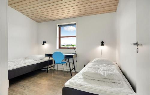 ロッケンにあるCozy Home In Lkken With Saunaのベッドルーム1室(ベッド2台、デスク、青い椅子付)