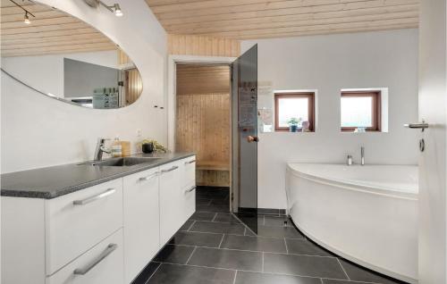 ロッケンにあるCozy Home In Lkken With Saunaの白いバスルーム(バスタブ、シンク付)