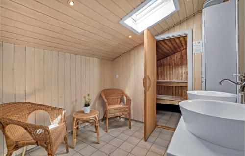 ロモ・キルケビーにあるAmazing Home In Rm With 4 Bedrooms, Sauna And Wifiのバスルーム(バスタブ、シンク、籐の椅子付)