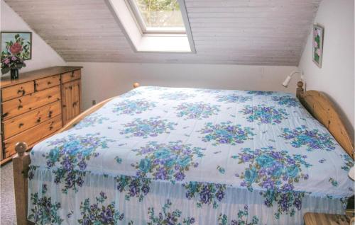 a bedroom with a bed with a floral bedspread at Lovely Home In Tranekr With Wifi in Hou