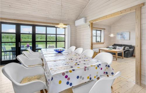 a dining room with a table and white chairs at Holiday Home Pilemose Sydals X in Skovby