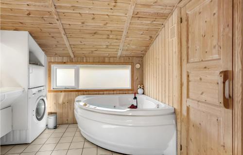 BolilmarkにあるBeautiful Home In Rm With 3 Bedrooms, Sauna And Wifiの木製の壁のバスルーム(白い大型バスタブ付)