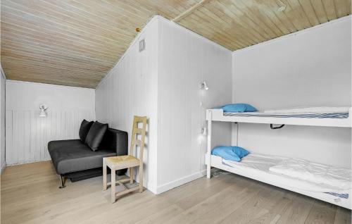 Bøtø ByにあるNice Home In Idestrup With 3 Bedrooms, Wifi And Saunaの二段ベッド2台と椅子が備わる客室です。