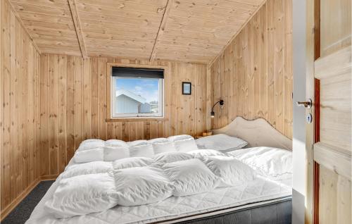 BolilmarkにあるBeautiful Home In Rm With 3 Bedrooms, Sauna And Wifiの木製の壁に白い大型ベッドが備わるベッドルーム1室