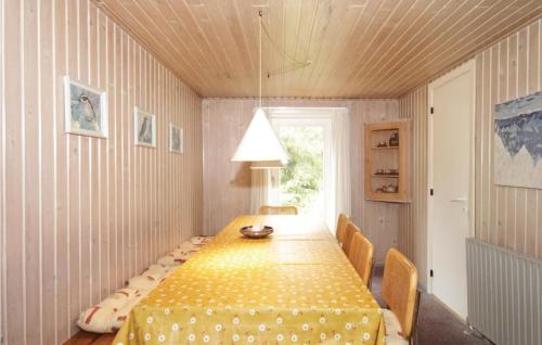 BjerregårdにあるAmazing Home In Hvide Sande With Wifiのダイニングルーム(テーブル、椅子、ランプ付)