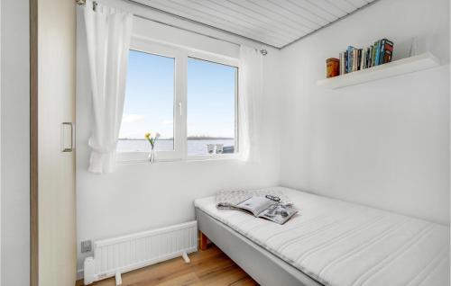 een witte slaapkamer met een bed en een raam bij Amazing Home In Otterup With House Sea View in Otterup