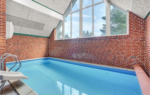 einen Pool mit Ziegelwand und Fenstern in der Unterkunft 6 Bedroom Stunning Home In Rømø in Toftum