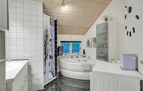 Baño blanco con bañera y lavamanos en Pet Friendly Home In rsted With Kitchen, en Ørsted