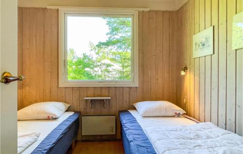 two beds in a room with a window at 3 Bedroom Stunning Home In Aakirkeby in Vester Sømarken
