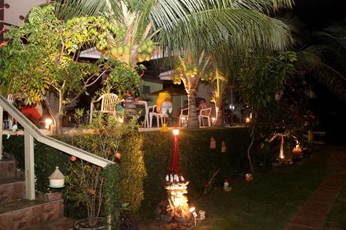 a garden with palm trees and lights in a restaurant at Pousada Recanto do Sal in Salinópolis