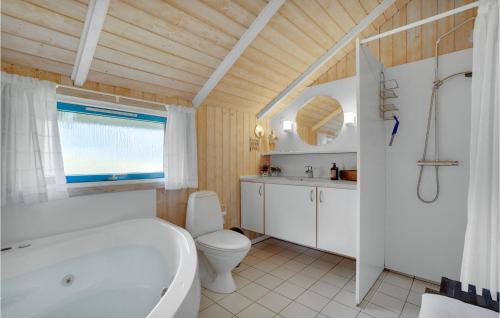 a bathroom with a white tub and a toilet at Cassiopeia in Fanø