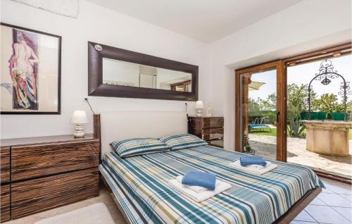 een slaapkamer met een bed met een spiegel aan de muur bij 2 Bedroom Gorgeous Home In Jurdani in Jušići