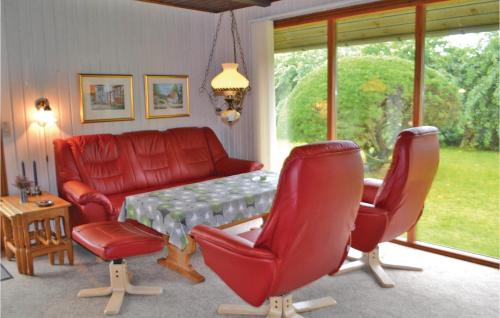 ein Wohnzimmer mit einem roten Sofa und Stühlen in der Unterkunft Holiday Home Støvlen in Hemmet