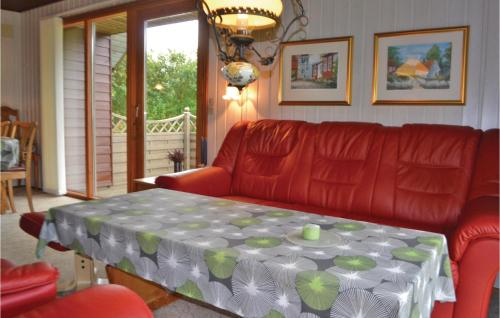 ein Wohnzimmer mit einem roten Sofa und einem Tisch in der Unterkunft Holiday Home Støvlen in Hemmet