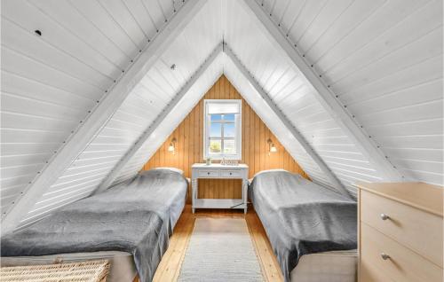 Bjerregårdにある3 Bedroom Gorgeous Home In Hvide Sandeのベッド2台と窓が備わる屋根裏部屋です。